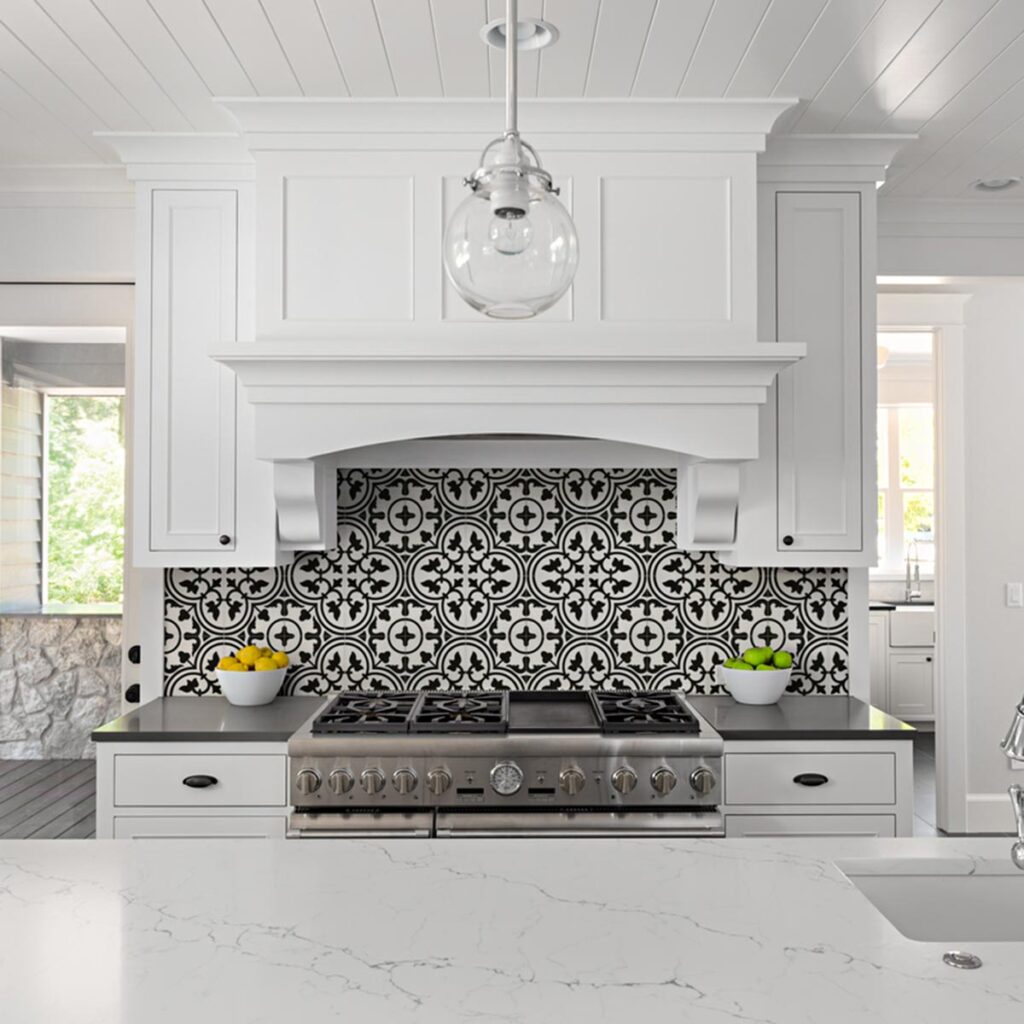 Black & white patterned tiles over a stove in a craftsman-styled kitchen.