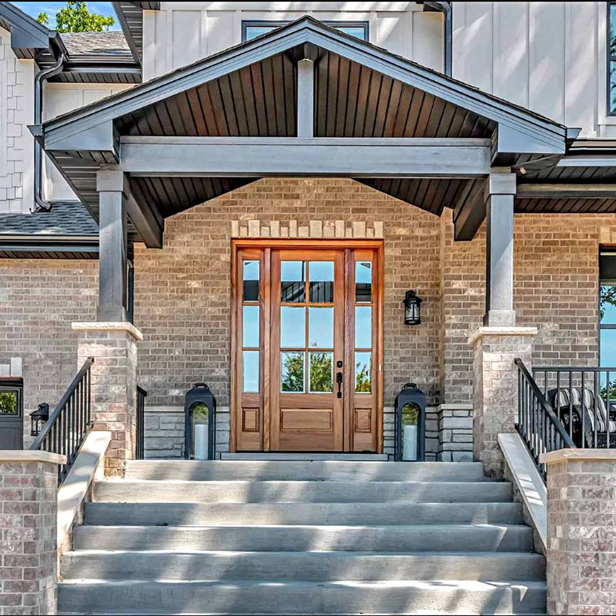 Front door ideas include a golden 6 panel wood front door with sidelites.