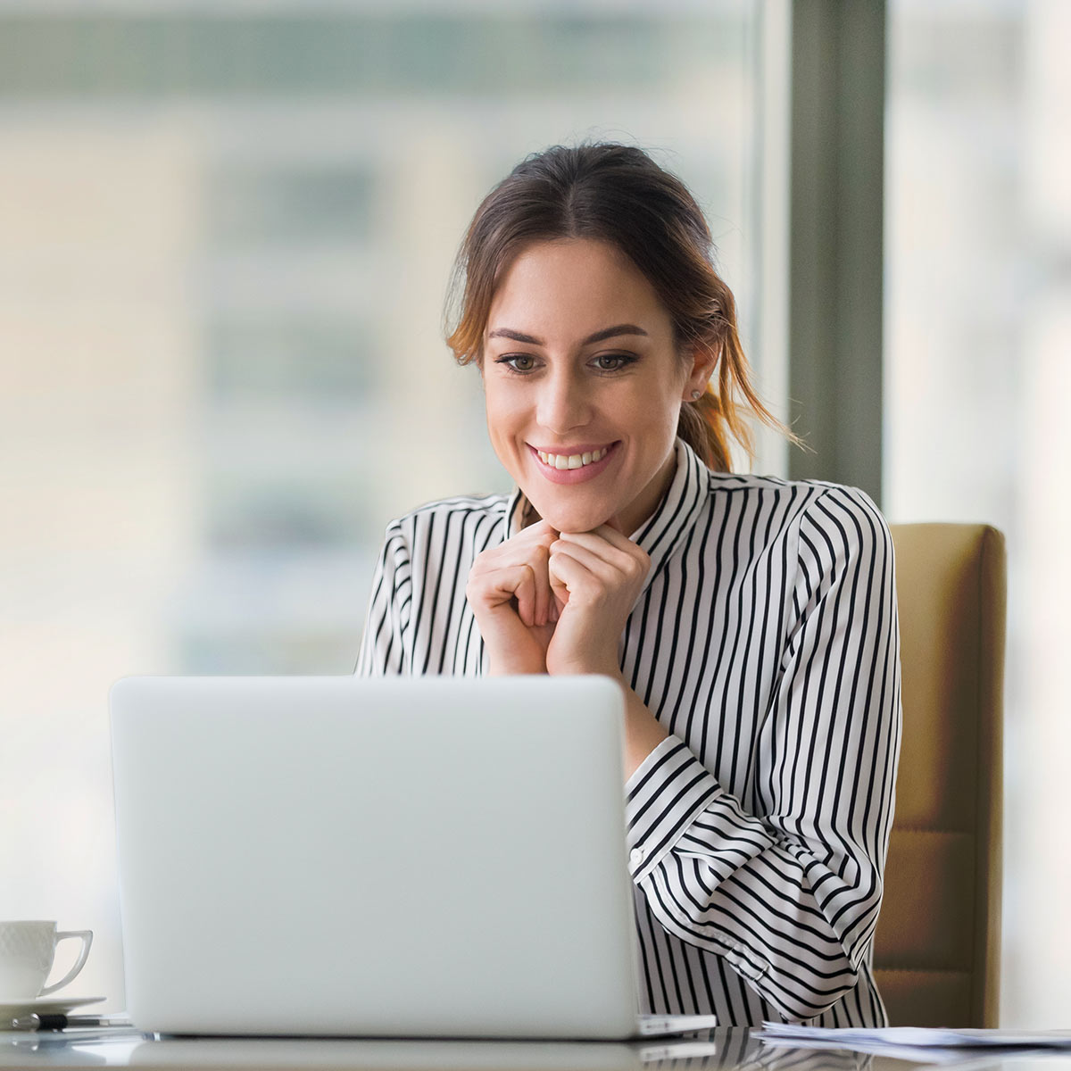 Female CEO looking at computer happy about site traffic from the Built for Home Product Guide.