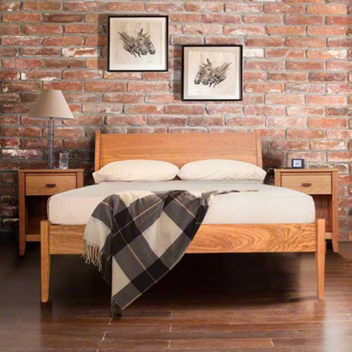 Copeland Furniture bed and nightstands made of light finished wood against a brick wall in a loft.