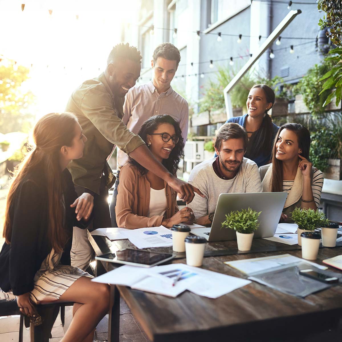 Office employees around a table outdoors collaborate during a strategic planning retreat